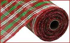 a roll of red and green plaid fabric with white stripes on the bottom, in front of a red frame