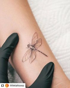 a woman's arm with a small dragonfly tattoo on the left side of her leg