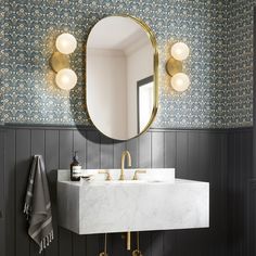 a white sink sitting under a bathroom mirror next to a wall mounted faucet