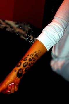 a woman's arm with a tattoo on it that has a leopard print on it