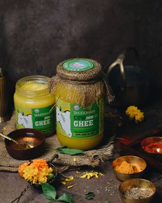 two jars of ghee sitting on top of a table