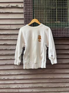 "Super cute vintage 1970s champion reverse weave raglan sweatshirt with Boston College embroidered letter appliqué. Some spots and all over wear but still in great condition with tons of life to give. Please see photos.  Measures  Chest 40\" Length 26\" Tags Champion Reverse Weave Warmup Size Small 90% cotton 10% Acrylic  Made in USA Please message me with questions before purchasing. All sales are final and ship quickly from our Vermont shop.  Find us on instagram @anasclosetfullofcolor Thankyo Vintage Cotton Crew Neck Sweatshirt, Vintage Pre-shrunk Crew Neck Sweatshirt, White Crew Neck Sweatshirt With Letter Patch, Retro Cotton Pre-shrunk Sweatshirt, Vintage College Sweatshirt With Embroidered Logo, Vintage Crew Neck Sweatshirt With Embroidered Logo, Streetwear Crew Neck Sweatshirt With Letter Patch, Vintage Sweatshirt With Embroidered Logo For College, Crew Neck Sweatshirt With Letter Patch For Streetwear