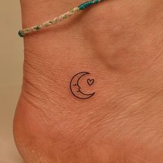 a small tattoo on the foot of a person with a heart and moon in the middle