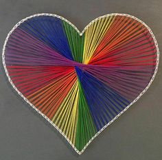 a heart made out of colored sticks on a gray card