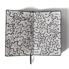 an open book with black and white designs on it