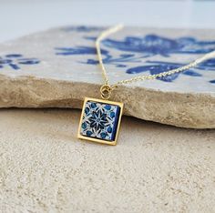 "Portuguese tile gold necklace, handmade with stainless steel square base and a blue and white mini 12 mm (or half an inch) square size wood tile, hand finished and varnished for protection and long lasting. ∙ DESCRIPTION & MATERIALS ∙ * Material: High Quality steel and dainty wood tile * Finish: Silver, Gold and Rose Gold * Featuring 14 mm x 14 mm wood square tile * Handmade in France * Anti allergic * Resistant & Durable * Handmade finish and detail * Each \"tile\" piece is sealed and coated with water based and nontoxic glaze, just like in ceramic pieces * Nickel and lead-free earring ear wires * Follow of the European norms for metal use safety * Ethical production * Perfect for gift giving on birthdays, weddings, anniversaries, Christmas, parties, vacations gifts, to go out with famil Blue White Tile, Portuguese Tile, Gold Jewelry Gift, Square Necklace, Free Earrings, Gift Handmade, Last Minute Gifts, Gold Pendant, Shop Earrings