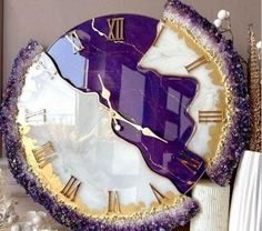 a purple and gold clock sitting on top of a table