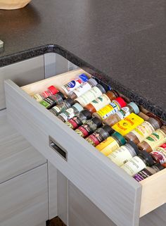 an open drawer with spices and condiments in it on a kitchen countertop