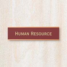 a red and gold sign that says human resources on the side of a wooden wall