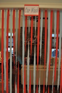 a room with red and white streamers hanging from it's walls, in front of a couch