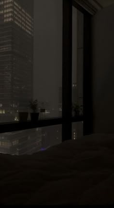 a bedroom with a view of the city at night