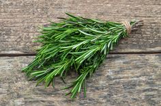 fresh rosemary sprigs on wooden planks ready to be used as garnishes