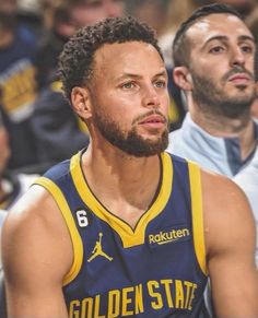 a basketball player sitting in the middle of a court with his head turned to the side