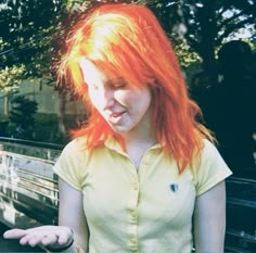 a woman with red hair holding something in her hand