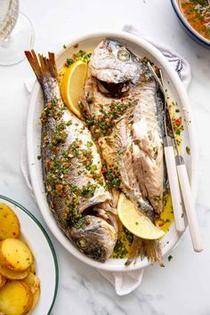 an image of fish with lemons and herbs on the side for garnish