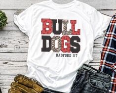 a t - shirt with the words bull dogs on it next to jeans and shoes