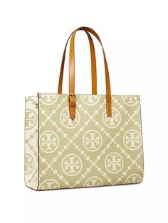 Tory Burch's leather tote flaunts an embossed monogram pattern..Dual adjustable shoulder straps.Open top.Side snap adjustments.Two interior compartments.Interior zip pocket.Interior slip pockets.Leather.Imported.SIZE.12.5''L x 15.75''W x 6''D.Shoulder strap drop, about 10''.ABOUT THE BRAND.Since debuting her brand in 2004, New York-based designer Tory Burch has made an impact on the fashion world with her handbags and shoes, and playful-yet-polished clothing. Today, Burch remains inspired by color and travel, with her vibrant collections bursting with prints, and her instantly recognizable double-T logo drawing from Moroccan architecture..Tory Burch's leather tote flaunts an embossed monogram pattern.Dual adjustable shoulder strapsOpen topSide snap adjustmentsTwo interior compartmentsInter Monogram Canvas Tote Shoulder Bag With Adjustable Strap, Tan Monogram Canvas Shoulder Bag With Handles, Tan Monogram Canvas Shoulder Bag For Errands, Tan Double Handle Coated Canvas Shoulder Bag, Tan Coated Canvas Shoulder Bag For Travel, Tan Signature Coated Canvas Shoulder Bag For Daily Use, Tan Signature Coated Canvas Bag For Everyday Use, Classic Tan Bags In Signature Coated Canvas, Everyday Tan Shoulder Bag In Signature Coated Canvas