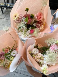 three bouquets of flowers are wrapped in pink paper