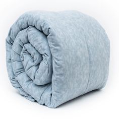 a blue comforter is folded up on a white surface