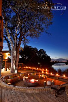 an outdoor fire pit with candles lit on the deck