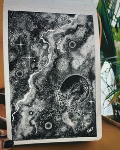 a black and white drawing on paper with cross in the sky, stars and planets