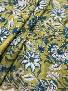 the fabric is green with blue flowers on it