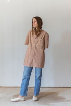 "This vintage workwear shirt has four white buttons, short sleeves and one left rounded pocket. Dusty Pink. Made in the 50s/60s. Garment Dyed in Los Angeles in 2020. Material: 100% Cotton 7 oz Condition: Good. Measurements-- -SMALL- Shoulders: 16.5\" | Chest: 19\" | Length: 28\" | Sleeve: 10.5\" -MEDIUM- Shoulders: 17\" | Chest: 21\" | Length: 30\" | Sleeve: 11\" -LARGE- Shoulders: 18\" | Chest: 23\" | Length: 30\" | Sleeve: 11\" -X-LARGE- Shoulders: 20\" | Chest: 25\" | Length: 30\" | Sleeve: 1 Utility Collared Top With Buttons, Unstructured Collared Tops With Buttons, Beige Collared Short Sleeve Shirt With Pockets, Everyday Short Sleeve Pre-washed Tops, Utility Cotton Tops With Buttons, Cotton Utility Tops With Buttons, Utility Short Sleeve Tops With Button Closure, Collared Short Sleeve Shirt With Pockets For Daywear, Retro Shirt With Pockets In Relaxed Fit