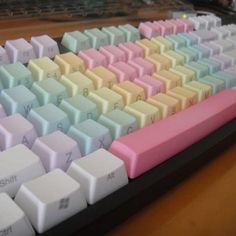 a computer keyboard sitting on top of a wooden desk