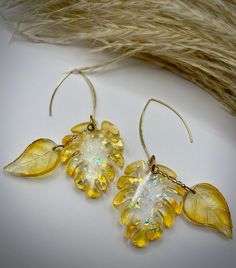 Dress up or dress down your fall outfits with these elegant and fun resin leaf earrings. These handmade earrings are one-of-a-kind, with two dangling leaves per earring and gold and glitter accents. Gold-colored wire is used along with hypoallergenic posts. Earrings drop about 4 inches. Resin Leaf, Earrings Drop, Etsy Earrings Dangle, Leaf Earrings, Handmade Earrings, Favorite Jewelry, Jewelry Earrings Dangle, Dangle Drop Earrings, Fall Outfits