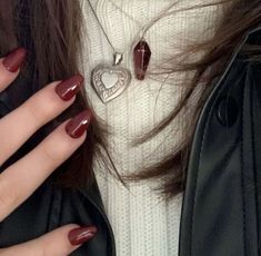 a close up of a woman's hands with red nail polish on her nails