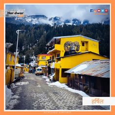 a yellow building with a lion painted on it's side in front of snow covered mountains