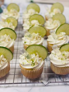 several cupcakes with cucumbers and white frosting on a cooling rack