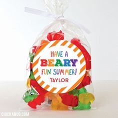 a bag filled with gummy bears sitting on top of a white table next to a sign that says have a berry fun summer taylor