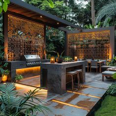 an outdoor kitchen and dining area is lit up at night