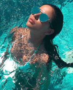 a woman wearing sunglasses floating in the water