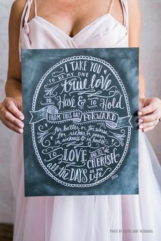 a woman in a white dress holding up a chalkboard with the words i take you full love on it