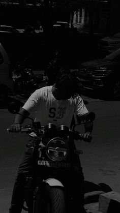 a man riding on the back of a motorcycle down a street