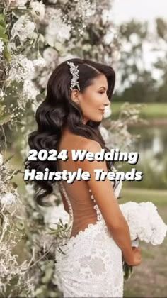 a woman in a wedding dress standing next to a tree with flowers on it and the words, 2020 wedding hairstyle trends