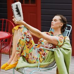 a woman sitting on a chair reading a book