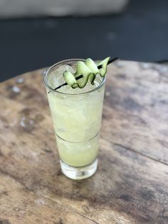 a glass filled with liquid sitting on top of a wooden table