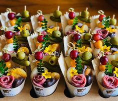 there are many small cups that have food in them on the table, and one is decorated with flowers