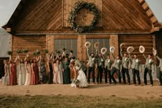 a group of people standing in front of a wooden building with wreaths on it