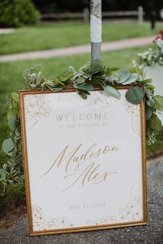 a wedding welcome sign with greenery on it