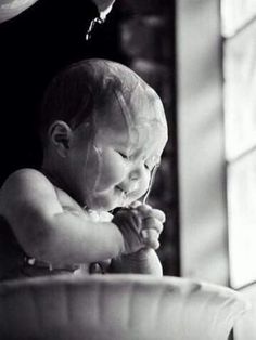 a baby sitting in a high chair with his hands on the water's edge