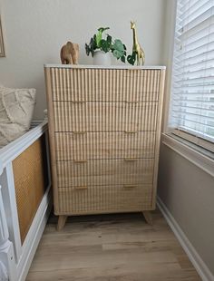 a wooden dresser sitting next to a window