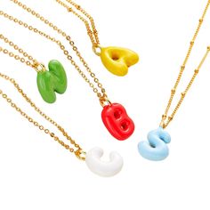 three necklaces with different colors and shapes on them, one is yellow, the other is red