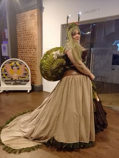 a woman dressed in costume standing on a wooden floor