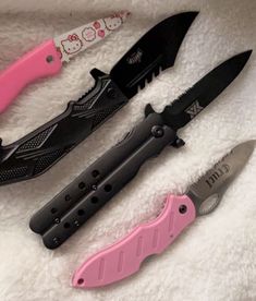 three different types of knifes laying on a white blanket with pink handles and black blades