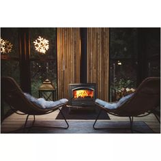 two lounge chairs facing each other in front of a wood burning stove