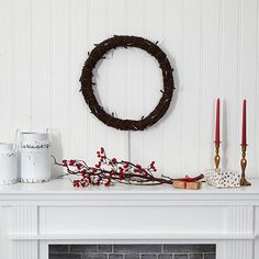 a mantle with a wreath and candles on it